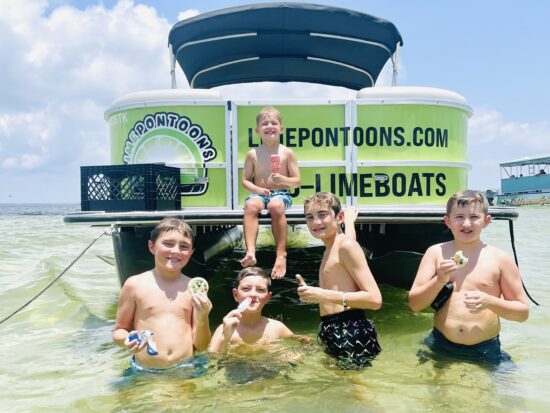 kids playing on crab island next to boat - lime pontoon rentals